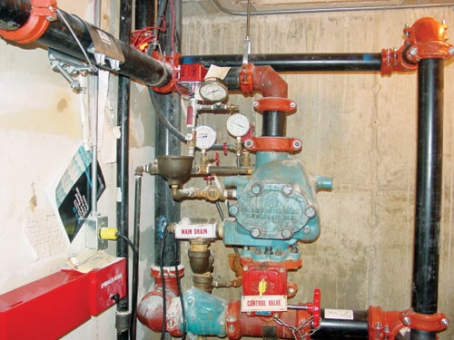 Fire sprinkler system with main drain and control valve signs