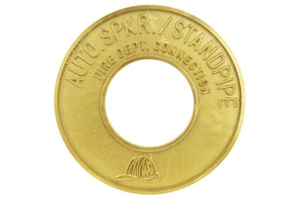 A round brass plate that reads "auto spkr standpipe"