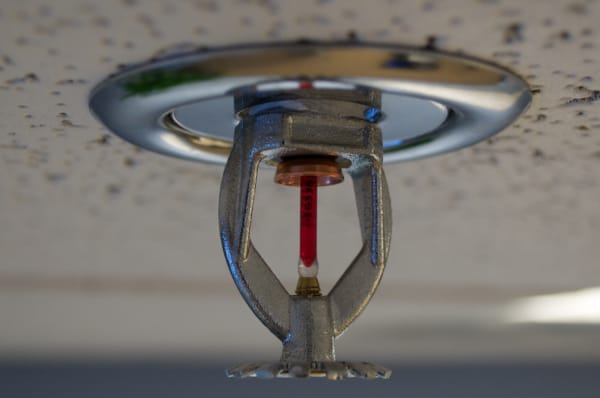 A chrome fire sprinkler hangs from the ceiling