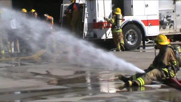 A firefighter sits on a hose