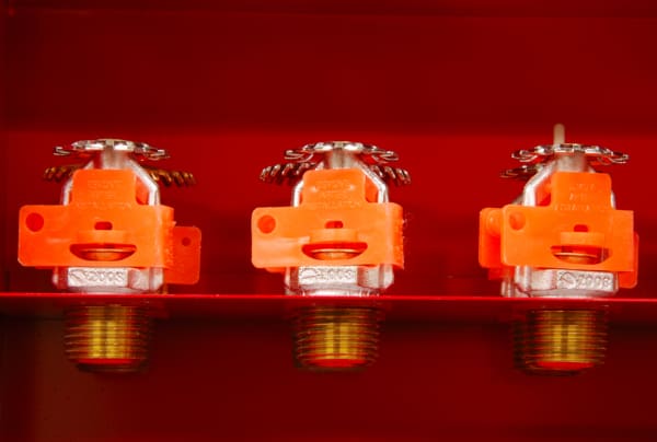 Three fire sprinklers in a cabinet