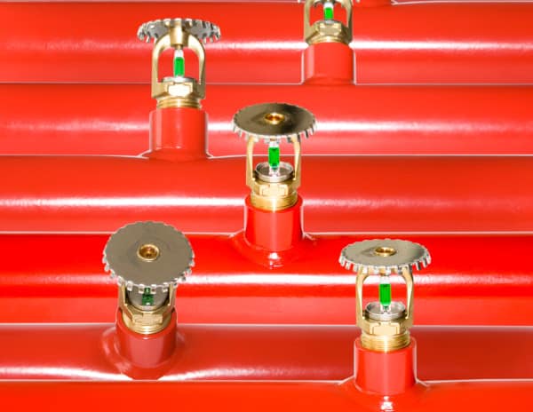 Fire sprinklers on red pipe