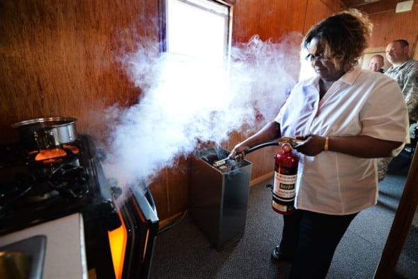 A woman training with a fire extinguisher