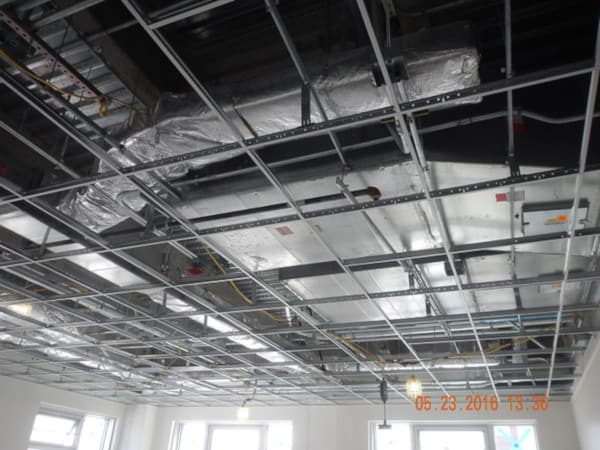 Exposed ceiling with fire sprinkler drops installed