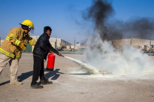 A dry chemical fire extinguisher being used