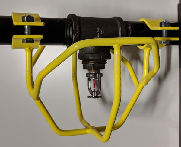 Yellow heavy-duty head guard protecting a sprinkler