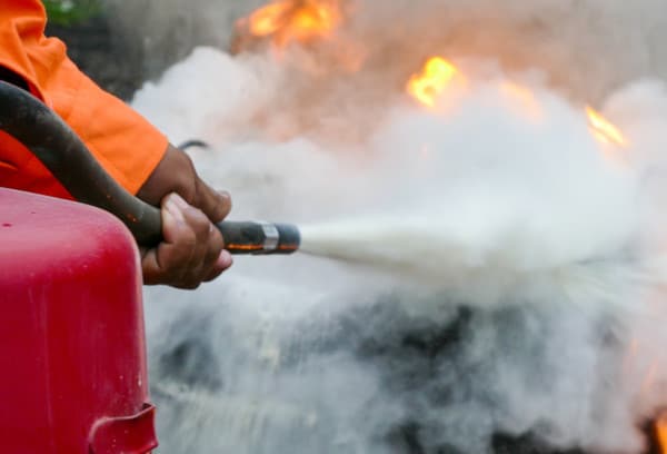 Fire extinguisher spraying on a fire