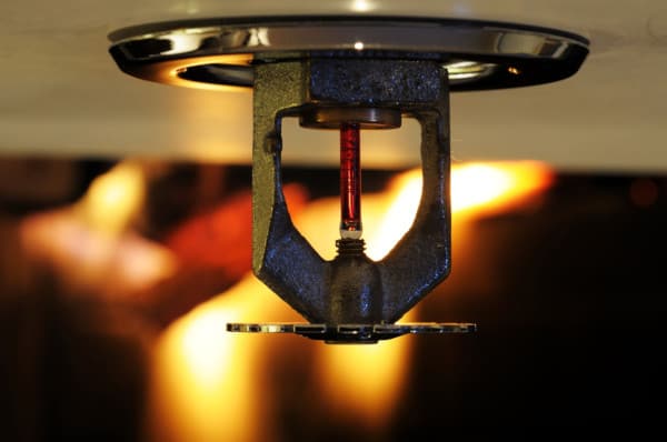 Flame behind a fire sprinkler