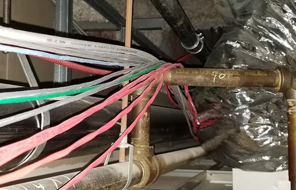 Wires hung over fire sprinkler pipe