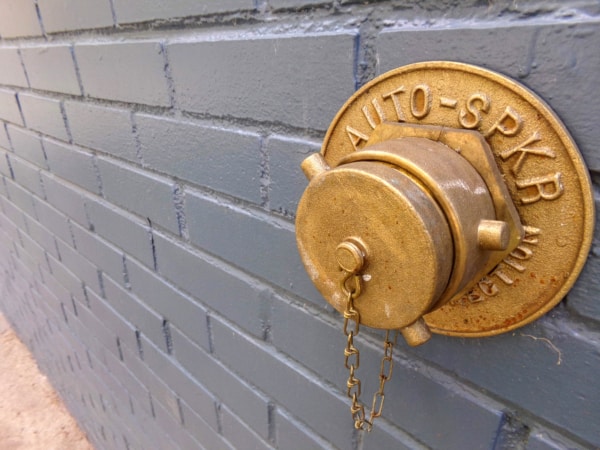 A brass-finished fire department connection plug and body