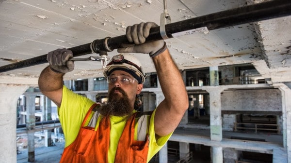 A sprinkler fitter working on a system