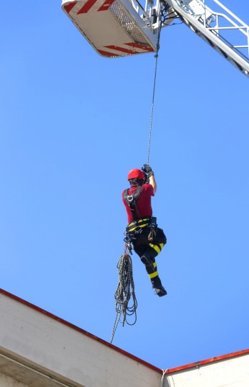 Firefighter hanging from rope