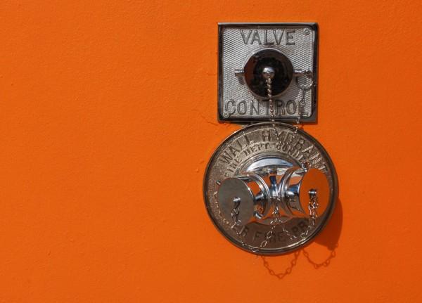 Wall hydrant on orange wall